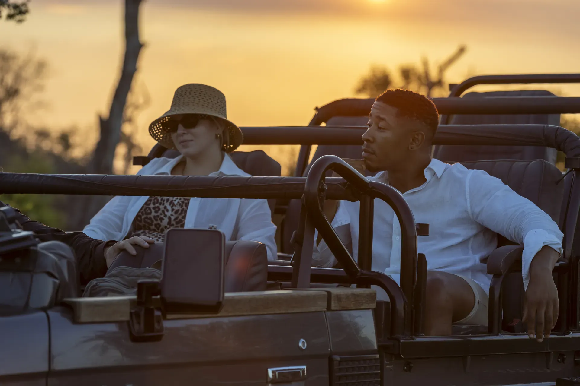 Private safari tour with guests seated in an open-top vehicle observing wildlife in the African bush