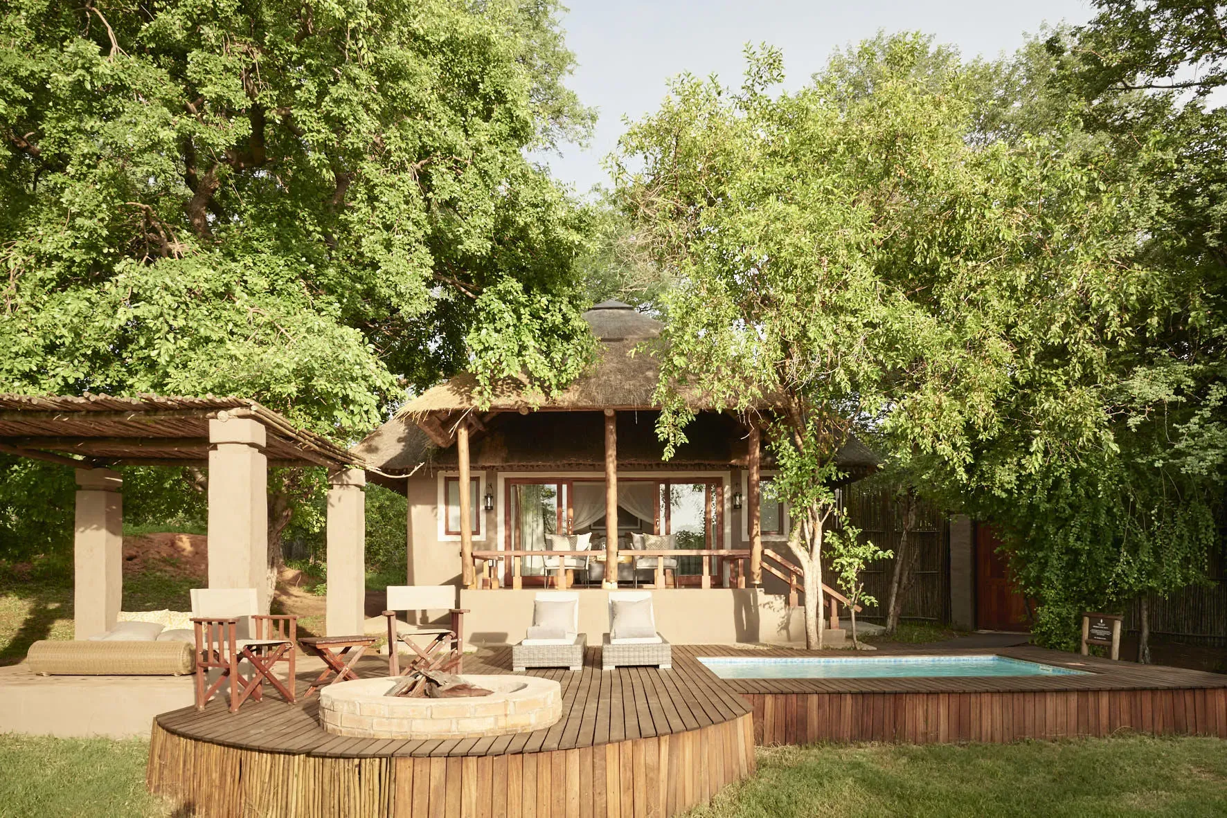 Sanctuary Chobe Chilwero lodge with wooden deck and thatched roof surrounded by lush greenery