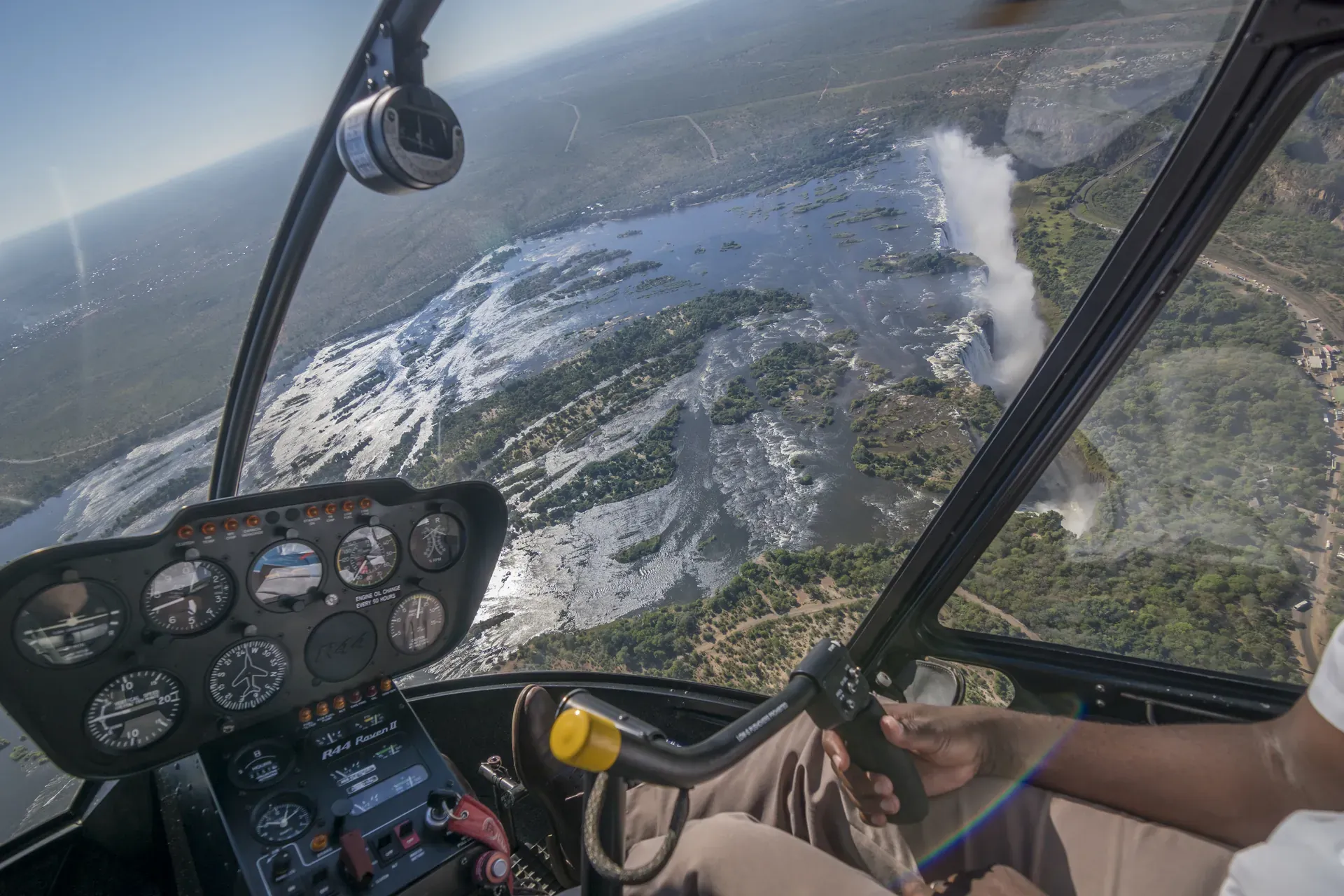 View from a helicopter flight over a scenic landscape with winding water channels and lush vegetation as passengers look out