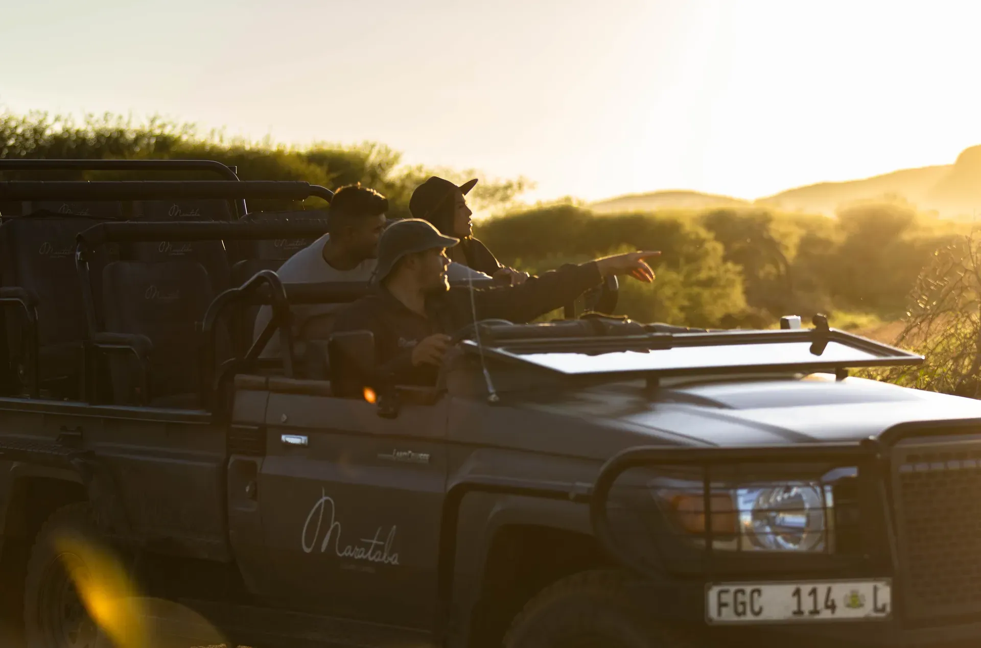 Safari vehicle parked for a mountain lodge game drive with scenic landscape in the background