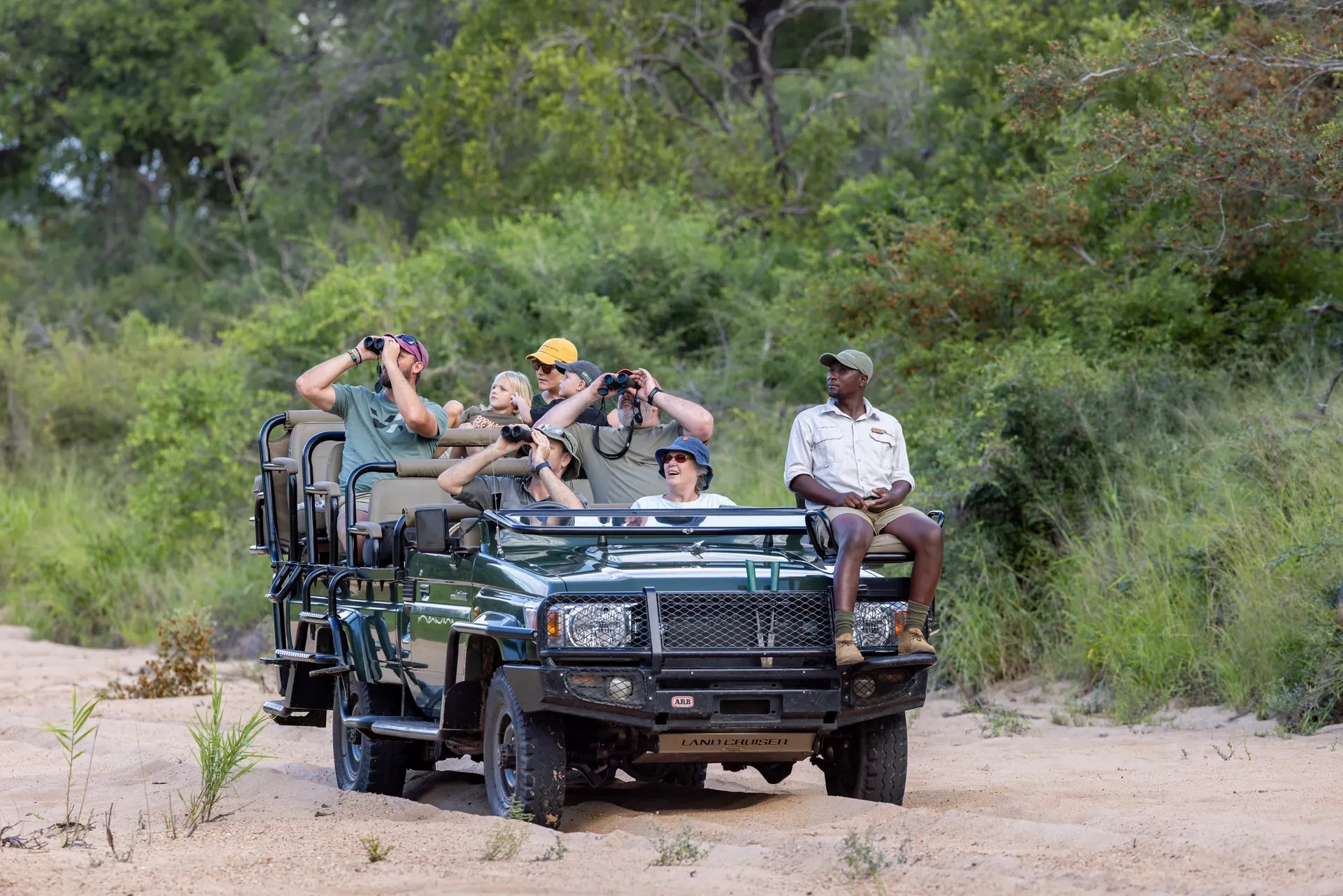 Safari crew coordinating logistics with vehicles and gear, preparing for a journey in the bush