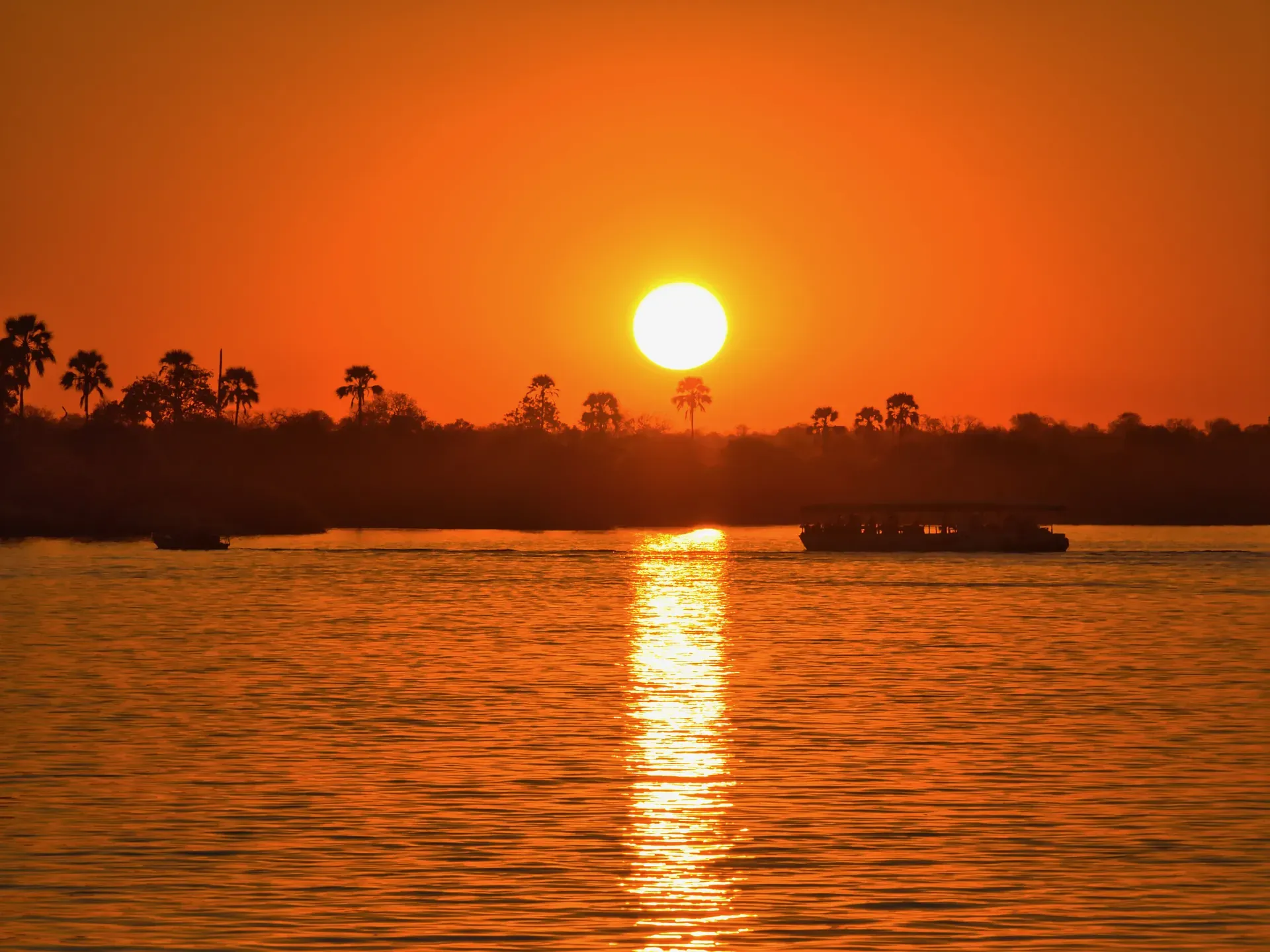 Sun setting over the river with a golden reflection on the water during a sunset cruise