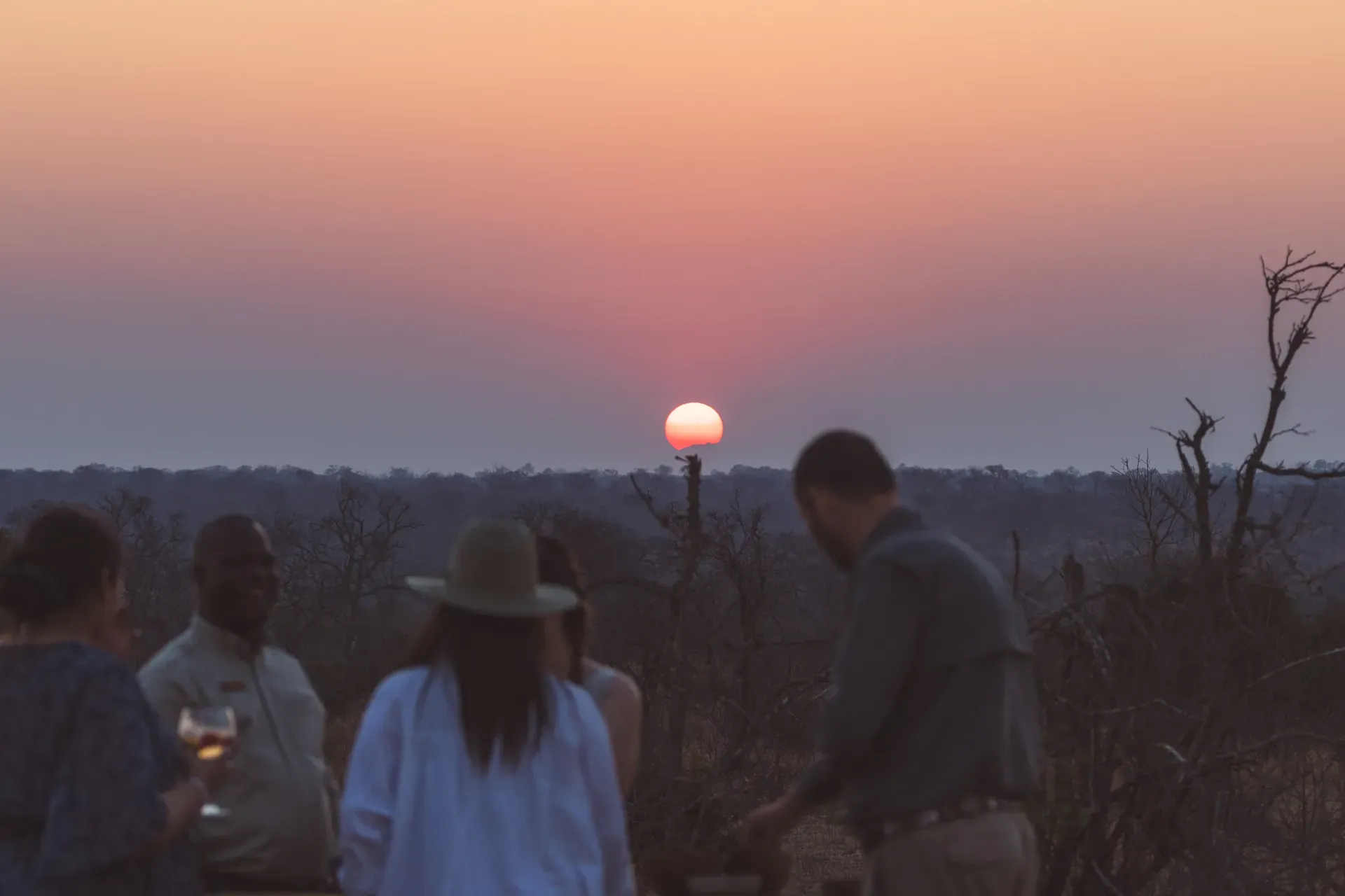 Community members gathering at sunset, building connections through conversation and togetherness
