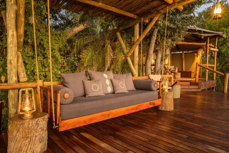 Kanana lodge outdoor lounge with cushioned sofas on a wooden deck under a thatched canopy
