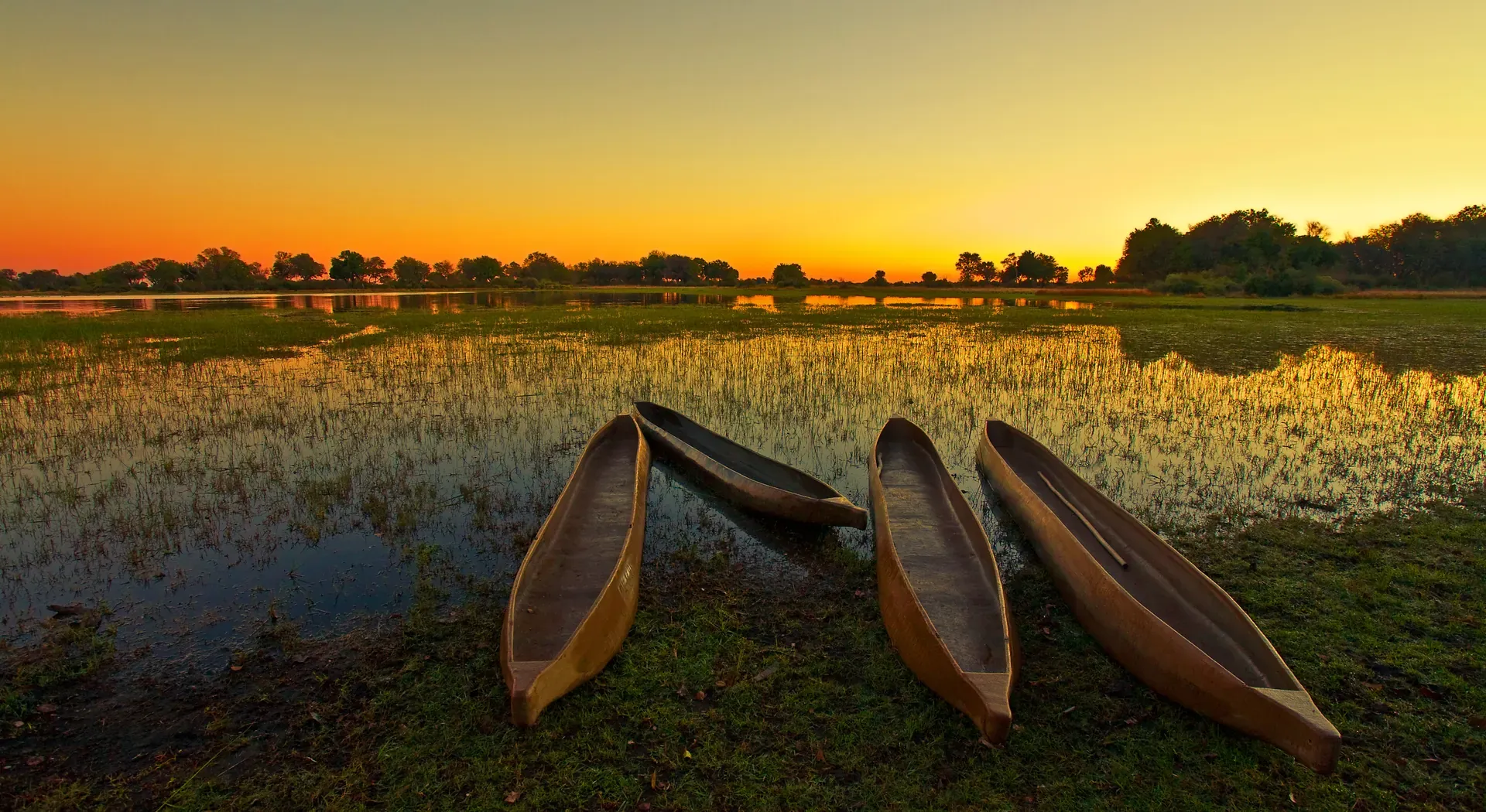 Two traditional mokoro canoes on a serene waterway at sunset, ready for a mokoro safari adventure